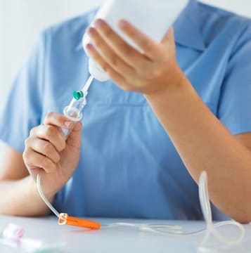 Врач держит в руках капельницу